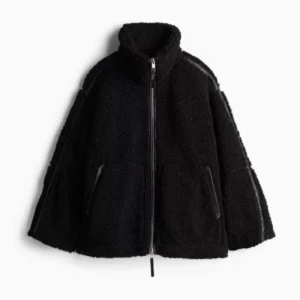 Svart teddyjacka med dragkedja - Mysig svart teddyjacka med dragkedja framtill. Jackan har en hög krage och två fickor på sidorna. Perfekt för kyliga dagar när du vill hålla dig varm och stilren.