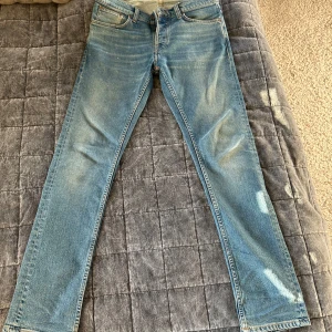 Ljusblå Nudie Jeans grim tim - Snygga ljublåa jeans. Byxorn är i mycket bra skick och är modellen grim tim. Nypris = 1600kr. Perfekta till våren :)