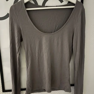 Grå långärmad topp - Säljer en stilren grå långärmad topp med rund halsringning. Kan bäras åt två håll,  Enkelt och snyggt basplagg för garderoben.💓