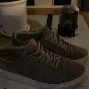 Grå sneakers från Vagabond - Snygga grå sneakers från Vagabond i mocka med klassisk snörning. Perfekta för en avslappnad stil. De har en vit sula som ger en fin kontrast till det gråa.