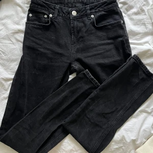 Svarta straightleg jeans - Snygga svarta straightleg jeansbyxor med låg midja från Vera Moda. Använda några få gånger men har fått aningen ljusa ”ränder” från att ha tvättats med för ljus tvätt i tvättmaskinen. Inget märkbart och försvinner säkert om de tvättas själva igen! Det är W26L34 och jag är 172 och det är precis lagom i längd på mig💕💕