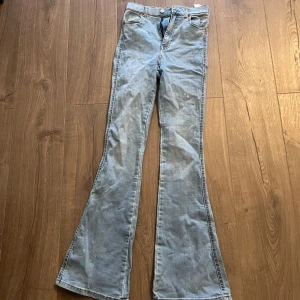 Ljusblå bootcut jeans från Dr. Denim - Snygga ljusblå bootcut jeans från Dr. Denim. Dessa jeans har en hög midja och en klassisk femficksdesign. Perfekta för en avslappnad stil med en modern twist. Passar bra till sneakers eller klackar.