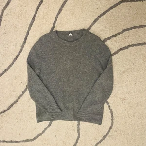 Grå ull tröja  - Säljer en stilren grå tröja i ull med rund hals och långa ärmar. Perfekt för kyligare dagar med ribbade muddar vid ärmslut och nederkant. Passar både till vardags och mer uppklädda tillfällen. Storlek XL men passar M då den har krympt, men det är enda defekten. Pris kan diskuteras🤝