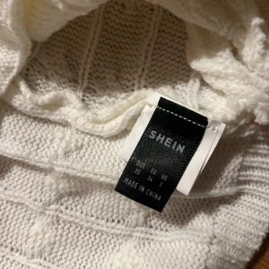 Vit stickad tröja från Shein - Säljer en vit stickad tröja från Shein. Tröjan har ett snyggt stickat mönster och långa ärmar. Perfekt för kyligare dagar. Passar bra till både jeans och kjol.