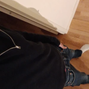 Slim half zip tröja - Säljer en stilren svart tröja med dragkedja. Perfekt för en avslappnad look. Tröjan har långa ärmar och en bekväm passform. Sitter extra tight vid midjan för ännu bättre passform.