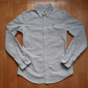 Blå och vit ralph lairen skjorta i storlek xs - ⭐️Ralph lauren ⭐️blått och vitt ⭐️Storlek = xs ⭐️Mycket bra skick ⭐️ frakt samma eller nästa dag  Supersnygg ralph lauren skjorta utan stora skador som påverkar utseendet. Axelsöm till axelsöm = 38cm Längd = 66 cm Armhåla till armhåla = 43 cm Kolla in min profil för andra snygga plagg och ställ gärna frågor