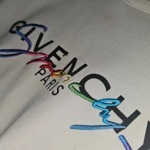 Vit sweatshirt från Givenchy - Säljer en stilren vit sweatshirt från Givenchy med färgglatt broderat logotyp på. Och självklart är den äkta! Men tyvärr inget kvitto på den då jag fick den utav min bror för ett tag sedan. Det är storlek L men passar även XL