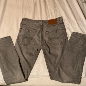 Grå Levis 502 jeans - Snygga grå Levis 502 jeans med klassisk design. De har en rak passform och är tillverkade i slitstarkt denim. STORLEK W28 L32.