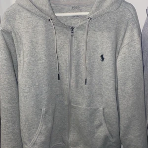 Säljer en grå Ralph lauren zip hoodie  - Säljer en fet Ralph lauren zip hoodie i väldigt bra skick. Använd några gånger men ingen skråma eller nått den är som ny! Priset är inte hugget i sten!