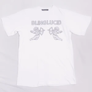Vit t-shirt med tryck från Bling Lucid - Snygg vit t-shirt från Bling Lucid med ett coolt tryck av två änglar och texten 'BLING LUCID' i glittriga detaljer. Perfekt för en stilren och trendig look.