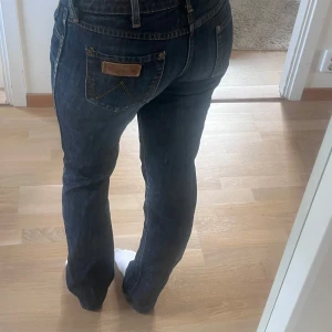 Wrangler jeans  - Skitsnygga mörkblå lågmidjade bootcut jeans från Wrangler 