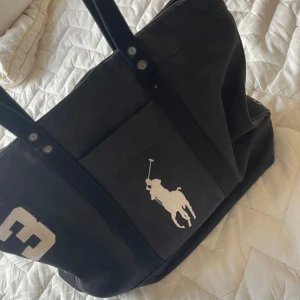 Snygg Ralph lauren väska  - Säljer på grund av att den inte passar min stil längre! Perfekt till skola då den får plats med allt. Mindre rost på knappar men det går säkert bort med medel, skriv vid frågor annars är det bara att trycka på köp nu!! 💕💕 