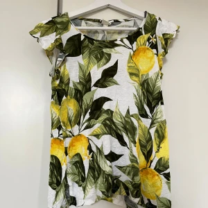 Blus med citroner  - Vit blus med citroner och blad mönster från HM i storlek S. Mycket bra skick.