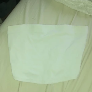 Vit tubtopp i storlek XXS - Säljer en enkel och stilren vit tubtopp i storlek XXS. Perfekt för sommardagar eller som ett basplagg i garderoben. Den är i bra skick och inte använd så mycket 