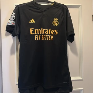 Real Madrid 23/24 tredjetröja - Jude Bellingham tröja från säsongen 23/24. Tröjan är oanvänd samt tags finns kvar. Säljer pga fel storlek.  Köpt för ca 1200 från Unisport. Inte matchtröja, men den är äkta. Pris kan diskuteras