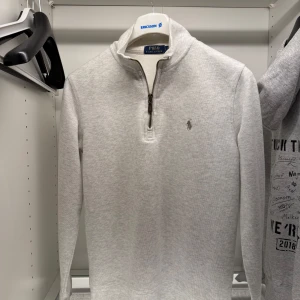 Grå tröja från Polo Ralph Lauren - Säljer en stilren grå tröja från Polo Ralph Lauren. Den har en dragkedja vid halsen och är långärmad. Perfekt för både vardag och lite finare tillfällen. Tröjan är i mycket bra skick och passar perfekt till höst och vår. Kan fraktas och tar endast Swish. Kör utanför denna appen Plick, då jag inte orkar att hålla på med returneringar/köparskydd osv. 