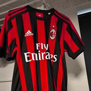 AC Milan fotbollströja med Suso autograf - Säljer en AC Milan fotbollströja i rött och svart med Suso's namn och nummer 8 på ryggen. Tröjan är i Climacool-material och har en autentisk autograf. Perfekt för samlare eller fans! 🖤❤️