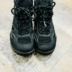 Svarta kängor från Ecco - Säljer ett par robusta svarta kängor från Ecco i mycket bra skick. De har en grov sula med orange detaljer för extra grepp och snörning för perfekt passform. Perfekta för höst- och vinteräventyr! 🥾