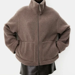 Ny brun pilejacka teddyjacka stl M från H&M - Ny med tags. pilejacka från HM Färg: brun / mörkbeige Storlek M (liten i storlek). Passformen är i en normal avslappnad form. Ta en eller två storlekar större än din vanliga storlek om du vill ha plats för en tjocktröja under annars kan det blir lite tajt.