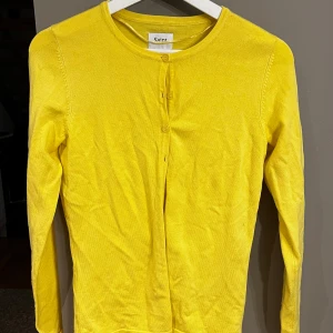 Gul kofta från Saint Tropez - Säljer en superfin gul kofta från Saint Tropez i storlek XS. Den är i bra skick och har långa ärmar med knappar framtill. 