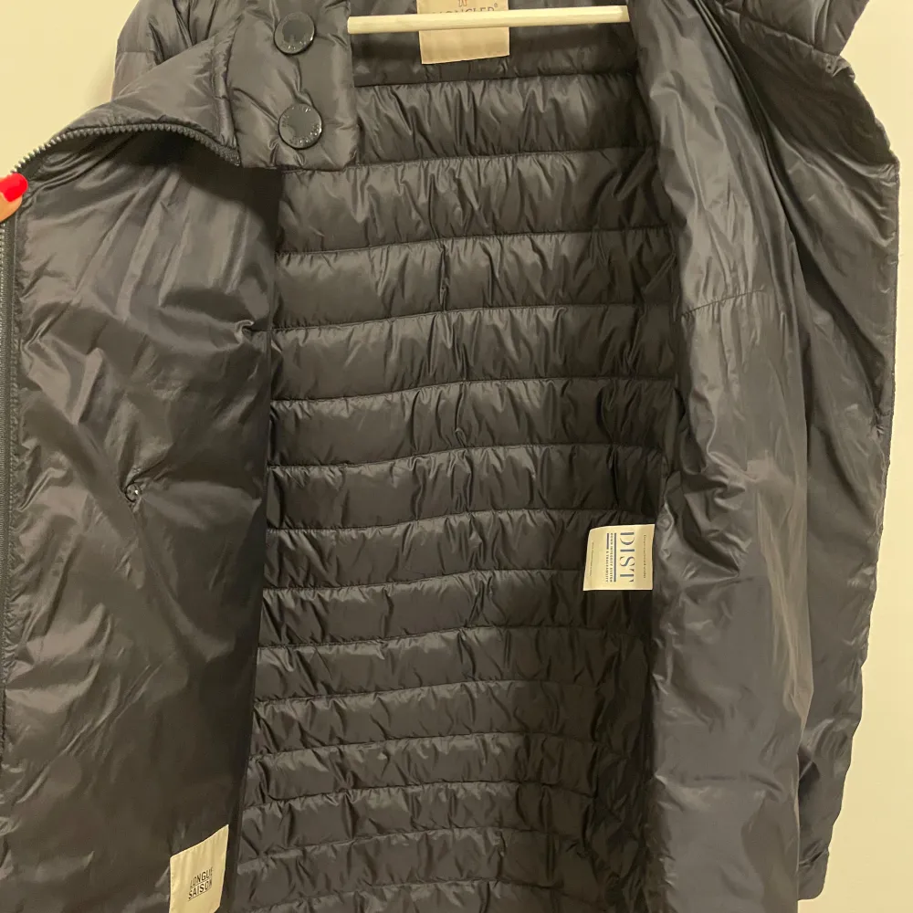 Säljer en snygg grå dunjacka från Moncler i mycket bra skick. Jackan har en quiltad design med dragkedja och knappar vid kragen. Perfekt för höst och vinter, håller dig varm och stilren. . Jackor.