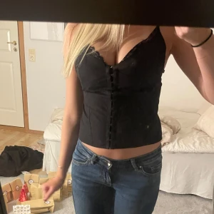 Svart korsett med spetsdetaljer - Snygg svart korsett i nytt skick med prislappen kvar så aldrig använd, köpte utomlands för 440kr