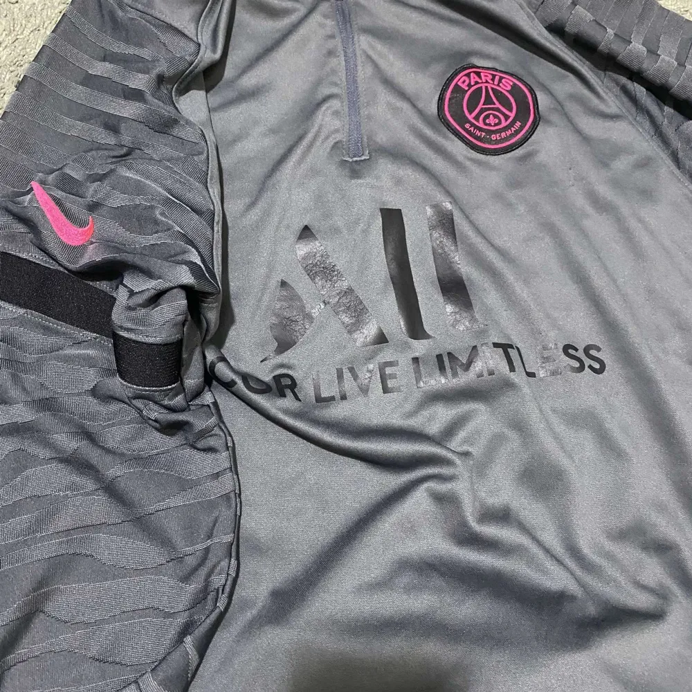 Säljer ett par grå PSG shorts från Nike med snygga rosa detaljer och logga. De har en elastisk midja och dragkedjefickor. Perfekta för fotbollsträningen eller bara för att chilla i. Materialet känns skönt och andas bra. Passar perfekt för sommarens aktiviteter! Priset är ej hugget i sten!. Shorts.