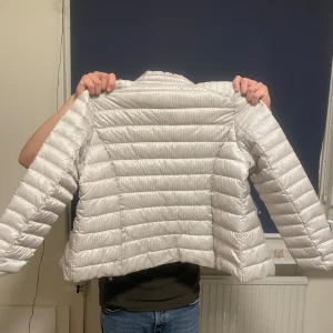Beige pufferjacka från Isolde - Säljer en snygg beige pufferjacka från Isolde. Jackan har en dragkedja framtill och är perfekt för kyligare dagar. Den är quiltad och har en stilren design som passar till det mesta. Perfekt för höst och vår. Den är som ny endast använd vid två tillfällen.