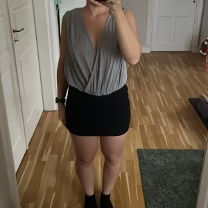 Silvrig omlottbody från BikBok - Säljer en snygg silvrig omlottbody från BikBok i storlek M. Den har en djup v-ringning och öppen rygg, perfekt för fest och nyår! Materialet är glittrigt och ger en extra touch. Passar bra till både kjol och byxor. Använd få gånger, så den är i mycket bra skick 🌟