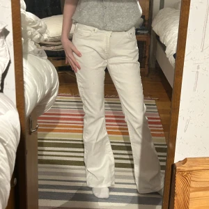 Vita bootcut jeans - Säljer ett par snygga vita bootcut jeans i mycket bra skick. De är lågmidjade och har en klassisk femficksdesign. Perfekta för både vardag och fest! Passar bra till en croppad topp eller en stickad tröja för kyligare dagar.
