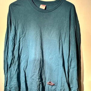 Blå långärmad tröja från Supreme - Säljer en snygg blå långärmad tröja från Supreme i storlek L. Tröjan är tillverkad i 100% bomull och har en cool Supreme-logga på baksidan. Perfekt för en avslappnad stil eller streetwear-look. Den är i bra skick och redo för nya äventyr! Tröjan är mycket sparsamt använd. Köpt i New York för 60$. Tveka inte att höra av dig om du har frågor eller vill ha fler bilder!