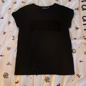 Svart t-shirt från Polo Ralph Lauren - Säljer en snygg svart t-shirt från Polo Ralph Lauren i storlek S. Den har en stilren design med ett diskret tryck på framsidan. Perfekt för en casual look eller att klä upp med en kavaj. Passar till alla tillfällen!