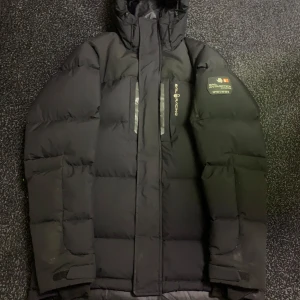 Svart dunjacka från Sail Racing - Säljer en svart dunjacka från Sail Racing i mycket bra skick. Jackan är perfekt för vintern med sin varma och vadderade design. Den har en dragkedja framtill och en praktisk huva. Perfekt för kalla dagar! 🖤pris det går så klart att diskutera 