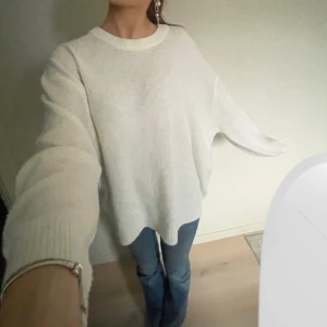 Vit mysig stickad tröja - Säljer en supermysig vit oversized tröja. Perfekt för kyliga dagar med sin lösa passform och långa ärmar. Den är enkel men stilren, och funkar till allt från jeans till kjol. Ett måste i garderoben för en avslappnad look! 🤍