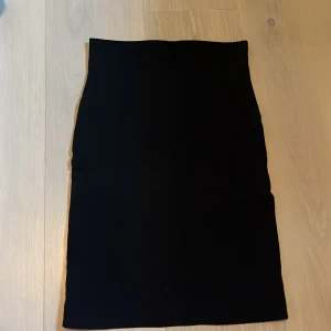 Svart kjol - Snygg svart kjol i klassisk stil. Perfekt för både vardag och fest. Den har en enkel design som gör den lätt att matcha med olika toppar och accessoarer. Ett måste i garderoben!