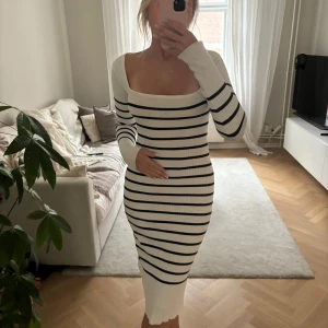 Vit och svart randig ribbad klänning - Säljer en superfin vit och svart randig klänning i ribbat material. Den har en tight passform och är långärmad med en elegant offshoulder-stil. Perfekt för både vår och höst! Klänningen är i mycket bra skick och passar perfekt till både vardag och fest.