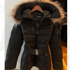 Hollies jacka  - Jag säljer min Hollies jacka i storlek xs/34, den är svart och har inga skador alls, det ända är att en knapp på pälskragen har lossnat men det fixar man enkelt med en säkerhetsnål som jag gjorde och det funkar perfekt och syns ingenting! Den är knappt använd och priset kan diskuteras vid snabb affär. 