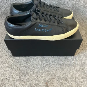 Svarta sneakers från Saint Laurent - Snygga svarta sneakers från Saint Laurent i skinn med vit sula | Passar bra nu även till vinter eftersom att de är i läder | Skick 8/10| Storlek 41 men passar även 42 | Likadan säljs för runt 3-3.5 | Box tillkommer även vid köp🙌