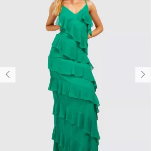 Grön långklänning med volanger - En superfin grön långklänning med volanger. Den är i tallmodell så perfekt för de som är lite åt de längre hållet, själv är jag 167 och den funkade bra bara jag hade lite klack! Klänningen har smala axelband och en vacker volangdetalj som ger en romantisk känsla. Använd bara en gång så är i nyskick🩷