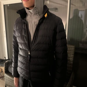 Dunjacka från Parajumpers - Säljer en snygg mörkblå pufferjacka från Parajumpers för killar i mycket bra skick. Jackan har en dragkedja framtill och en patch på ärmen. Perfekt för höst och vinter, håller dig varm och stilren. Är i storlek Y- M i kidsstorlek och är detsamma som XS/S i vuxenstorlek. Endast använd ett fåtal gånger. Köptes för 4800 kr men säljes för 1000 kr💕