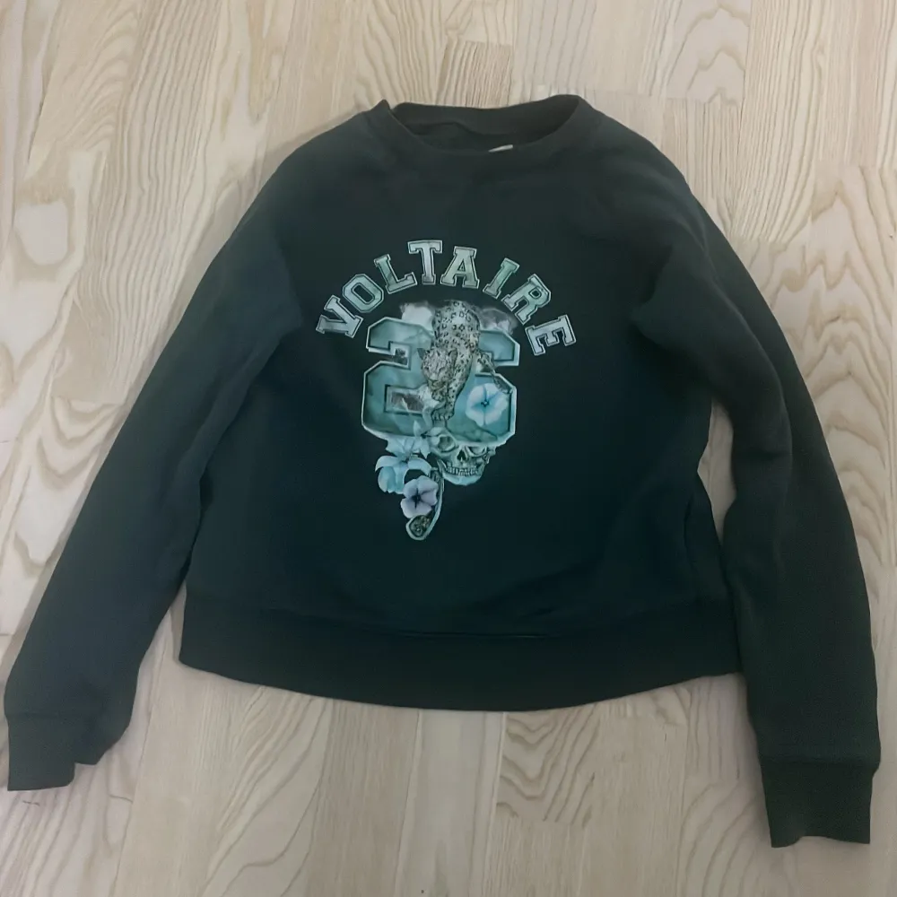 Säljer en snygg mörkgrön sweatshirt från Zadig & Voltaire. Den har ett coolt tryck med texten 'Voltaire' och en leopard på framsidan. Tröjan är i bra skick och superbekväm!. Tröjor & Koftor.