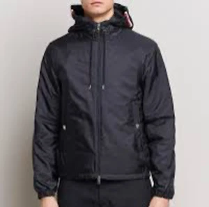 Svart vindjacka med huva - Säljer en stilren svart vindjacka med huva. Jackan har dragkedja framtill och är perfekt för blåsiga dagar. Den är långärmad och har en normal passform. Perfekt för vår och höst!