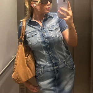 Jeansklänning - Kortärmad jeansklänning med knappar, dragkedja längst ned. Köpt på Sellpy i bra skick, sparsamt använd.