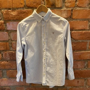 GANT Skjorta - Gant Skjorta i storlek 152. Skick 8/10. Skjortan kommer givetvis tvättas och strykas innan leverans. Finns en liten fläck men går säkert på i tvätten! Skriv vid minsta fundering! Nypris: Ca 600kr mitt pris 199kr