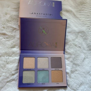 Aurora Glow Kit från Anastasia Beverly Hills - Säljer en superfin Aurora Glow Kit från Anastasia Beverly Hills. Paletten innehåller sex olika highlighters i nyanserna Eclipse, Luna, Spectra, Helia, Orion och Lyra. Perfekt för att ge ansiktet en magisk glow! Förpackningen har en snygg gradient i lila och blått.