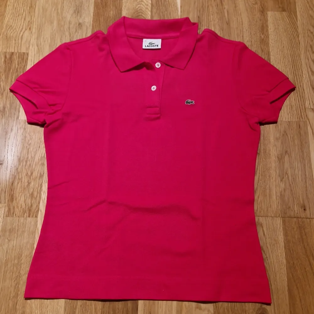 Denna piké är i färgen rosa och är i storlek 42. Pikén funkar med t shirt under men även utan. Skjortan kommer från Lacoste och är i väldigt bra skick, skjortan har aldrig använts.Pris kan diskuteras.. Skjortor.