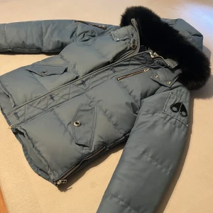 MOOSE KNUCKLES CHAMBRAY BLUE - Otroligt bekväm och unik vinterjacka av Moose Knuckles i färgen chambray blue. Väldigt fin svart päls. Använd 2 vintrar därav det billiga priset.   Kan tänka mig byta mot en annan moose knuckles, canada goose eller burberry jacka❗️