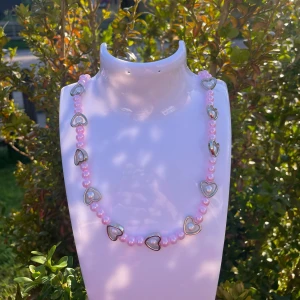 Pärlhalsband  - Söt och stilren - vårt rosa pärlhalsband med hjärtdetaljer 🌸🩷