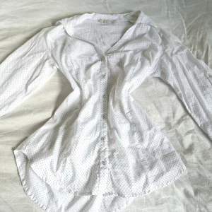 Vit prickig skjorta från Stradivarius - Säljer en superfin vit skjorta från Stradivarius med små svarta prickar. Skjortan är i storlek L och är gjord av 100% bomull, vilket gör den både bekväm och andningsbar. Den har långa ärmar och knappar hela vägen ner. Perfekt för både vardag och fest! 🖤