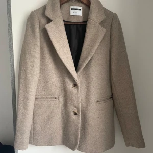 Kappa - Noysi May kappa i färgen beige, helt oanvänd. Nypris 699. Perfekt nu till hösten. Storlek XS men passar även S med en stickad tröja under.